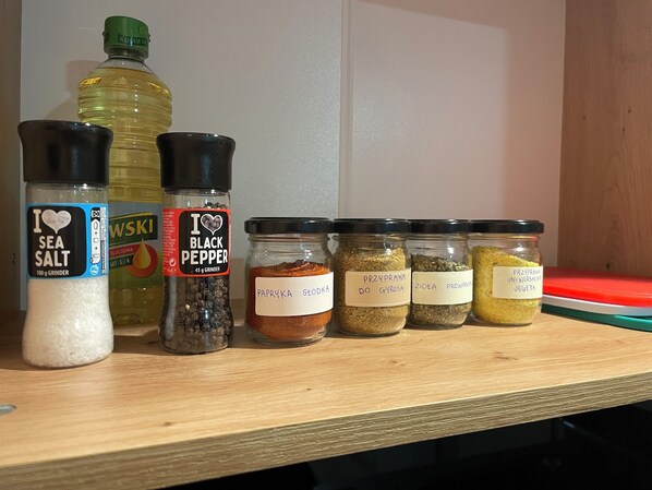A shelf with various kitchen spices and condiments, including sea salt, black pepper, and several labeled jars of paprika and other seasonings. - Cozy Apartment located in the City Center in Dębica with WiFi, pet-friendly (Dębica)