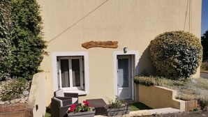 Un edificio con un letrero que dice "La Belle Aline". Tiene dos ventanas y una puerta, con escalones que conducen a la entrada.
