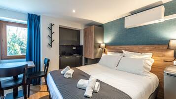 A modern hotel room with a bed, a desk, and a chair.
