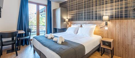Habitación de hotel moderna con una cama grande, un escritorio y vistas al exterior.
