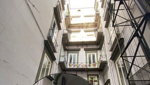 Une rue étroite avec une voiture garée et une voiture bleue sur le côté gauche.
