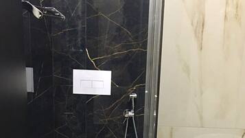 Un baño con inodoro, ducha y lavamanos.
