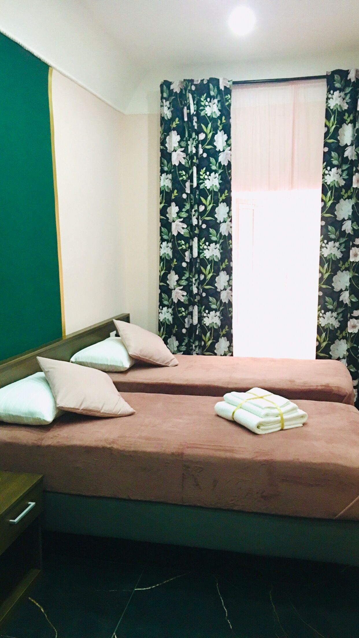 Une chambre avec deux lits, chacun étant équipé d’un oreiller et d’une serviette pliée.