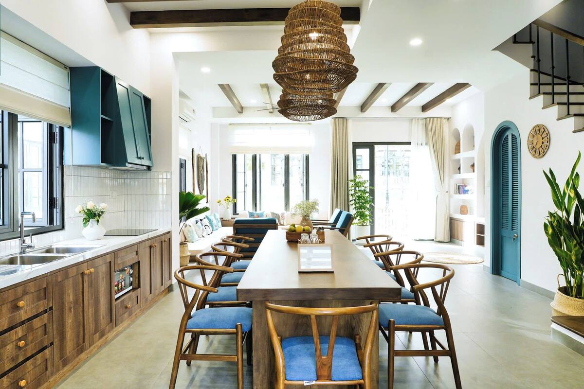 A modern kitchen with wooden cabinets, a large island, and blue chairs.