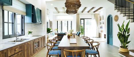 Una cocina moderna con armarios de madera, una isla grande y sillas azules.