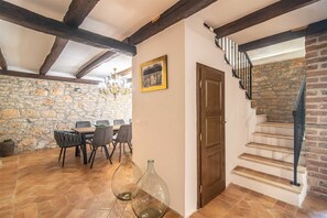 Enjoy meals in the dining area with a chandelier and stone wall backdrop.