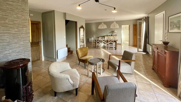 A spacious living area with a dining set and a kitchen in the background. - New " Villa Nova " (Cornillon Confoux)