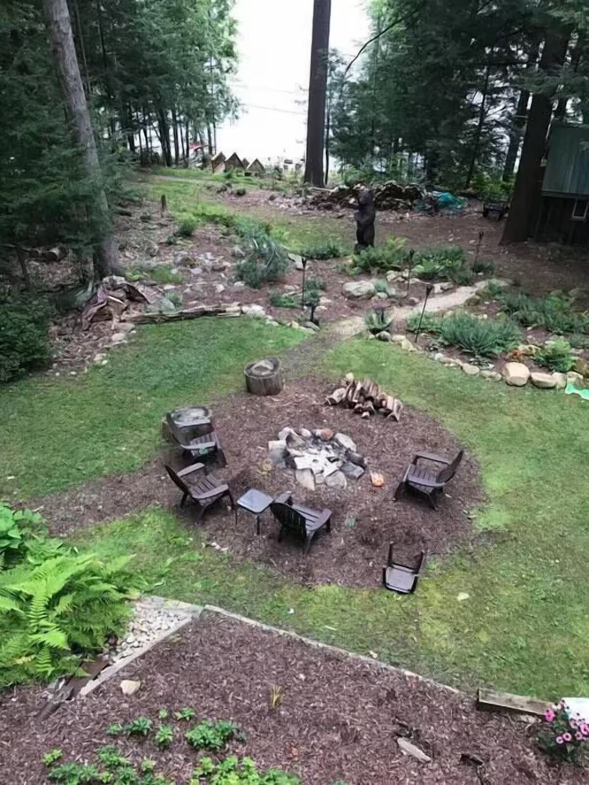 Un patio trasero con un brasero, zona de estar y un pequeño jardín.
