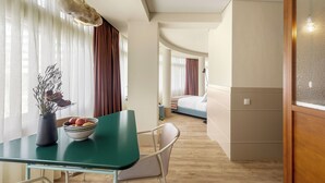 Une chambre d’hôtel moderne comprenant un coin repas, un lit et une salle de bain.