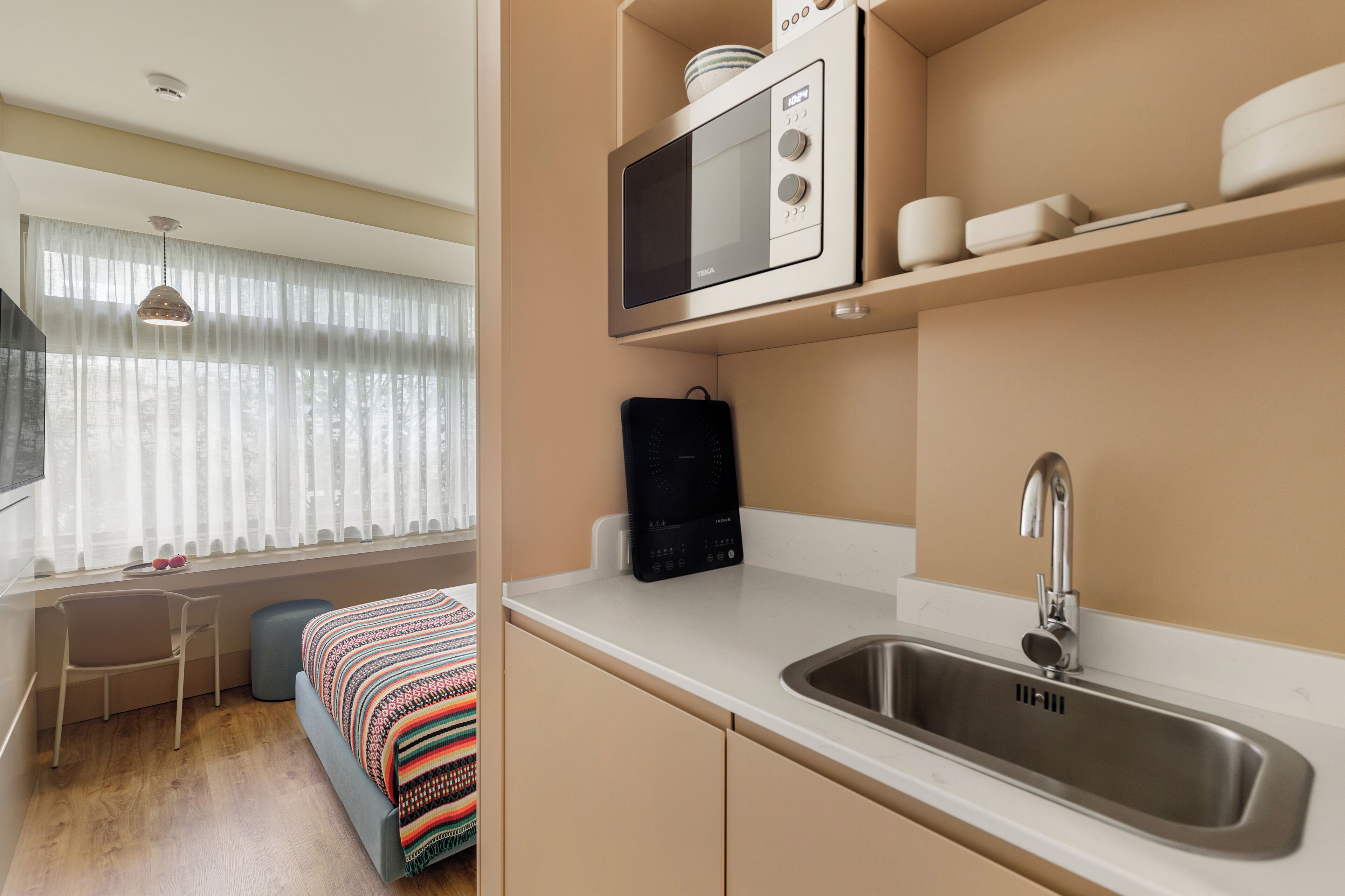 A compact kitchen with a microwave, sink, and a small countertop.
