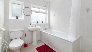 A bathroom with a toilet, sink, and bathtub. - Refurbished 4-bed Family Home-near Central London (London)