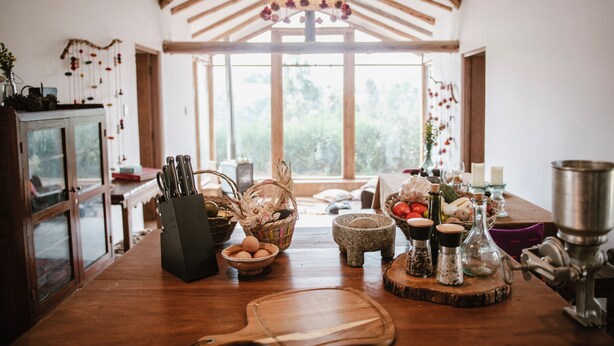 A kitchen with wooden beams, a large window, and various kitchen utensils and decorations. - Country house in the middle of nature. (Chinchero)