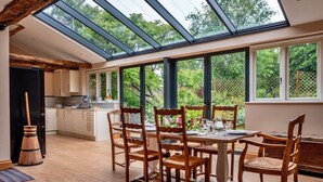 Una cocina moderna con un tragaluz grande, una mesa de comedor de madera y sillas.