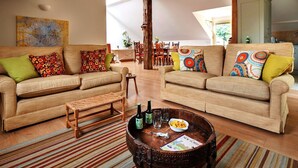 Un salon spacieux avec deux canapés, une table basse et un coin repas à l’arrière-plan.