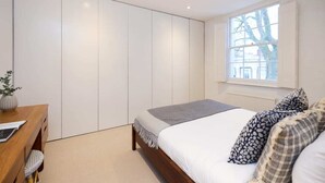 A bedroom with a bed, bedside table, and a window. - The Chelsea Classic - Splendid 3bdr House With Terrace (London)