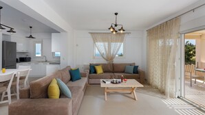 A modern living room with a sofa, coffee table, and dining area.