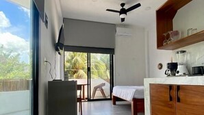 A modern kitchen with a dining area, large windows, and a view of palm trees. - Edificios Regam (El Cuyo)