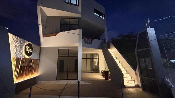 A modern multi-story building with a staircase leading to the upper levels. - Edificios Regam (El Cuyo)