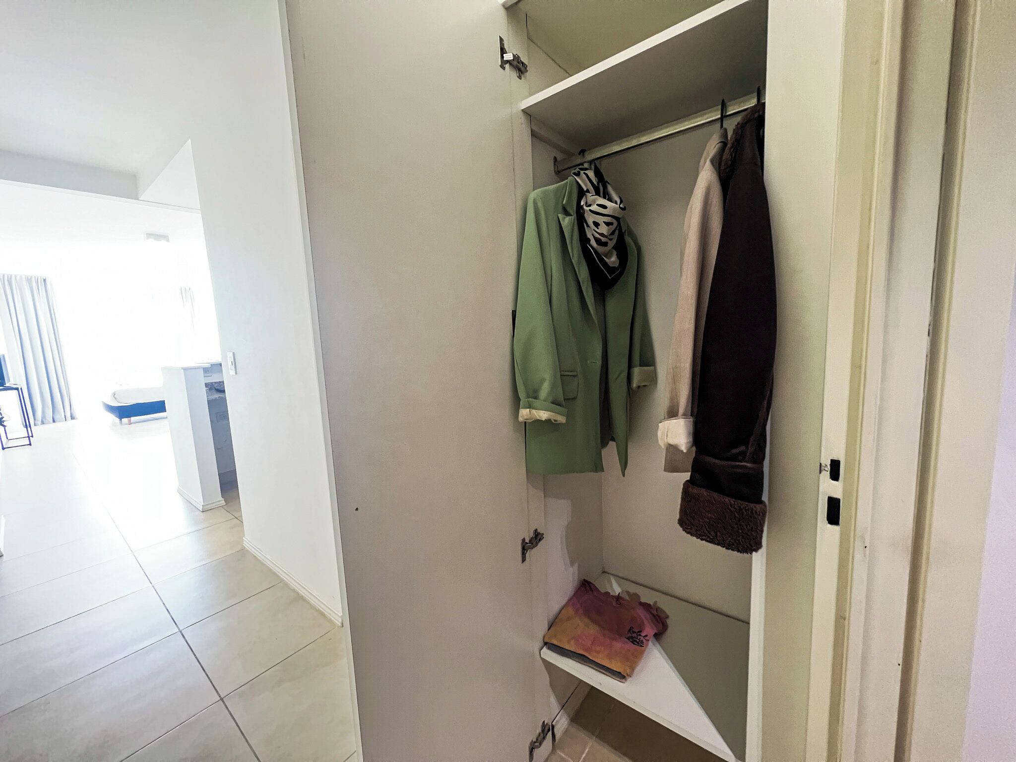 Ein begehbarer Kleiderschrank mit Kleiderstangen und Ablagefläche.