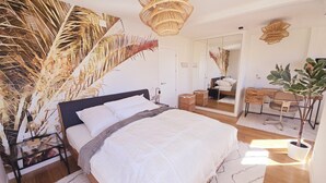 Une chambre à coucher avec un lit, une table de chevet et un grand miroir.