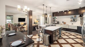 A modern kitchen with a central island, pendant lighting, and a checkered floor pattern. - Spacious 4BR pool home, billiards, BBQ, large patio, pool and pool deck (Tampa)