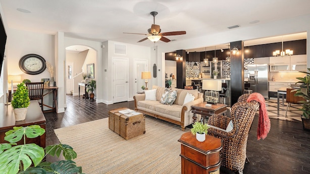 A spacious living room with a sofa, coffee table, and a dining area with chairs and a table. - Spacious 4BR pool home, billiards, BBQ, large patio, pool and pool deck (Tampa)