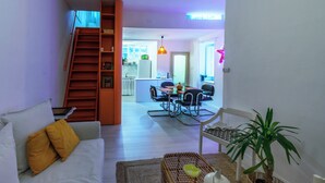 Un salon comprenant un canapé, une table basse et un escalier menant à l’étage supérieur.