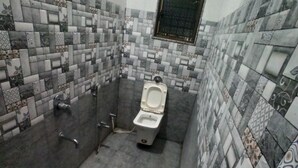Ein Badezimmer mit gefliestem Boden, Toilette, Waschbecken und Badewanne.