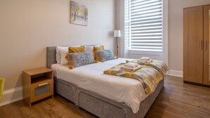 A bedroom with a bed, bedside table, and a wardrobe. - City Haven Main Door & Parking - Pass the Keys (Glasgow)