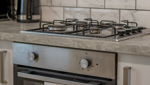 A kitchen with a gas stove, a coffee maker, and a microwave. - City Haven Main Door & Parking - Pass the Keys (Glasgow)