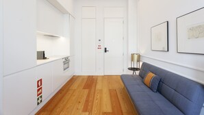 Un intérieur moderne comprenant une cuisine, un canapé et une porte signalée comme issue de secours.
