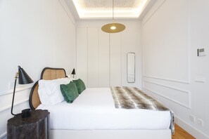 A bedroom with a bed, bedside lamp, and a ceiling light fixture. - Unique Chiado by Misha s Place (Lisbon)