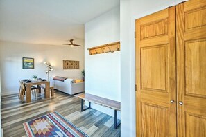 Un salon moderne avec un plancher en bois, une table à manger, un canapé et un banc.