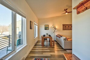 A hallway with a dining table and chairs, a sofa, and a ceiling fan.