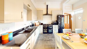 Una cocina moderna con una isla central, estufa, horno y refrigerador.