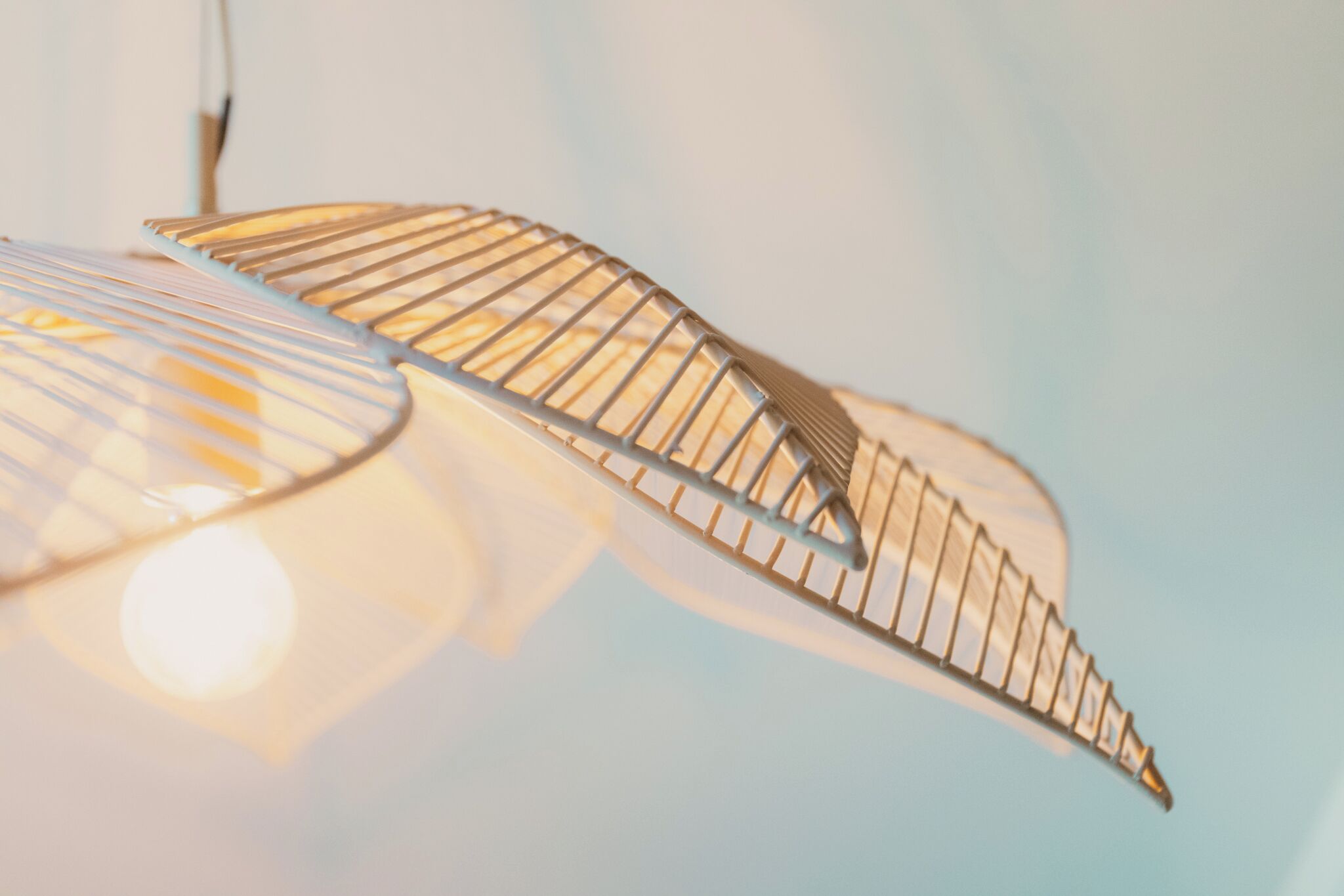 Primer pla d'una làmpada metàl·lica amb forma de fulla i superfície reflectant.