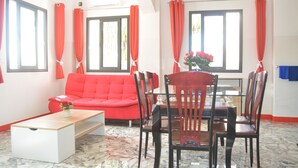 Una sala moderna con un sofá rojo, una mesa de centro de madera y una mesa de comedor con sillas.
