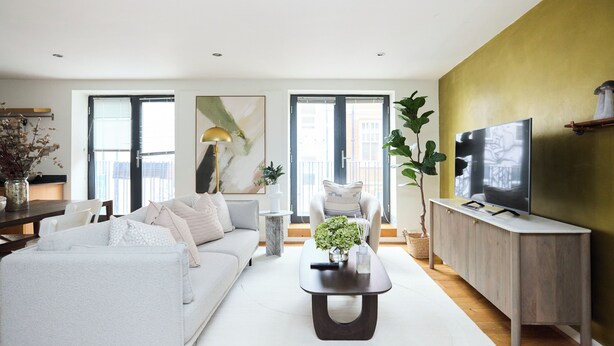 A modern living room with a sofa, coffee table, and TV stand. - The Shoreditch Retreat - Inviting 2bdr Apartment (London)