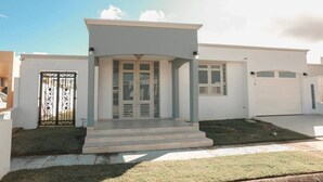 Ein modernes, zweistöckiges Haus mit überdachter Veranda, Garage und befestigtem Eingang.