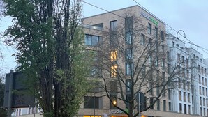 Monikerroksinen rakennus, jossa on moderni arkkitehtoninen tyyli, suuret ikkunat ja huomiota herättävä sisäänkäynti.