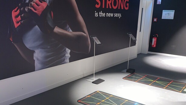 A fitness area with exercise equipment, a motivational poster, and a fire extinguisher. - Frankfurt Studio 226: Your Retreat Near the Main Train Station and Messegelände! (Frankfurt am Main)