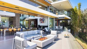 A modern open-plan living area with a fireplace, seating, and a dining area.