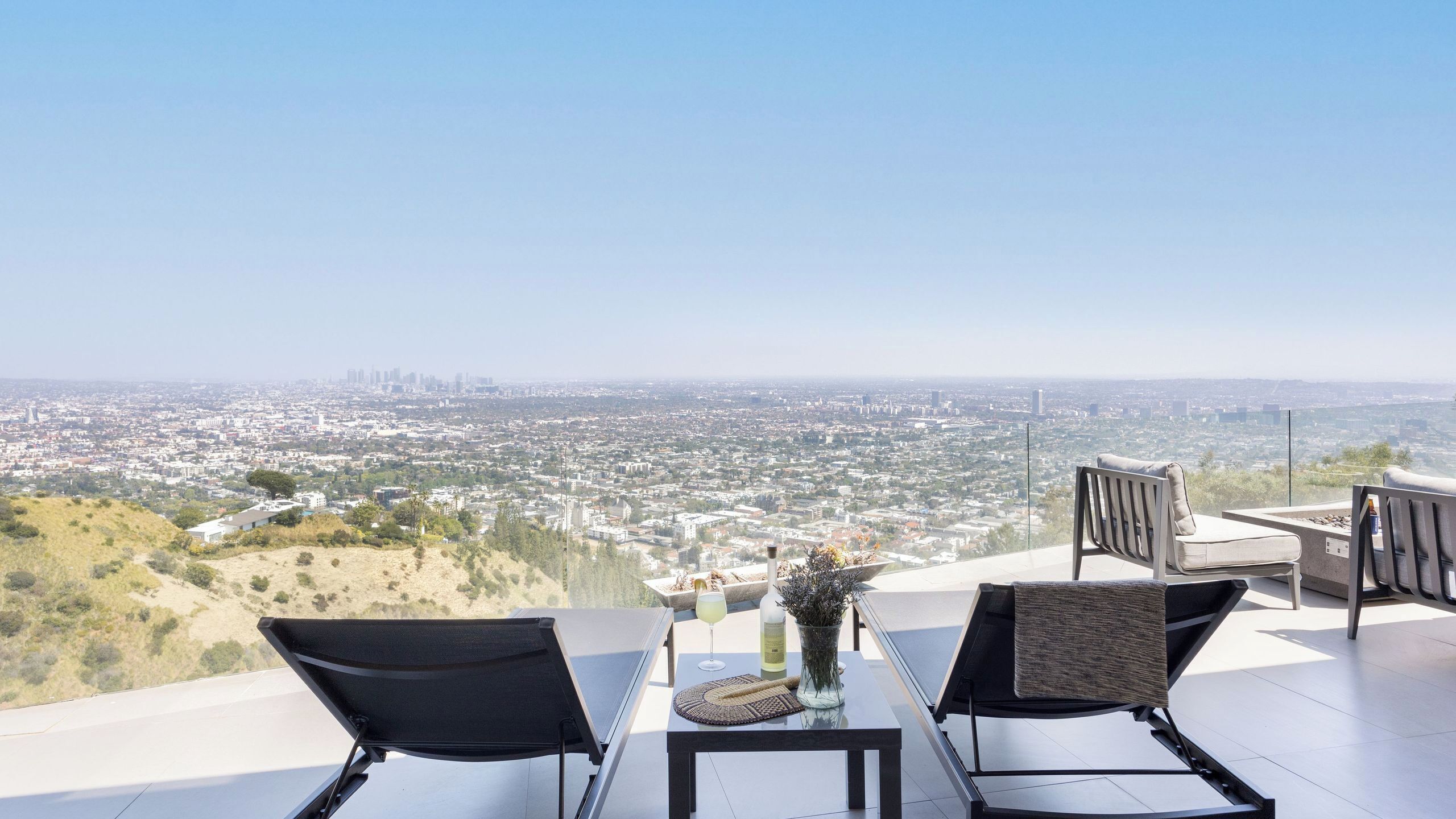 Eine Terrasse mit zwei Stühlen, einem Tisch und Blick auf die Stadt.