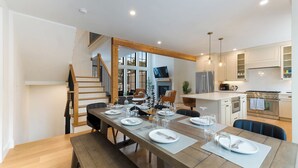 A modern kitchen with white cabinets, a stainless steel refrigerator, and a built-in oven. - Brand NEW Ski-in/Ski-out retreat at Cranmore Mt.! (North Conway)