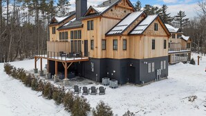 A large wooden cabin with a covered deck and multiple windows. - Brand NEW Ski-in/Ski-out retreat at Cranmore Mt.! (North Conway)