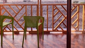 A wooden deck with two green chairs facing a beach view. - TUPTUP - Resto & Resort (Cox's Bazar)