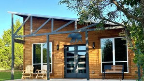 A modern wooden building with large windows and a metal roof structure. - Cozy, Rustic Cabin w/ Pool Table, Foosball, & Fast WiFi, South of Norman (Purcell)