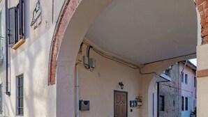 A building with a large arched entrance, a door, and a mailbox. - Luvi Maison - Affitti Brevi Italia (Terrazzano)