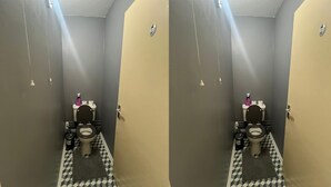 A bathroom with two toilets, each with a black seat and lid, and a white toilet paper holder on the wall. - Haven 2 Bedroom (London)