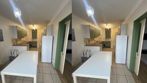 A compact kitchen with a white table, green cabinets, and a white refrigerator. - Haven 2 Bedroom (London)